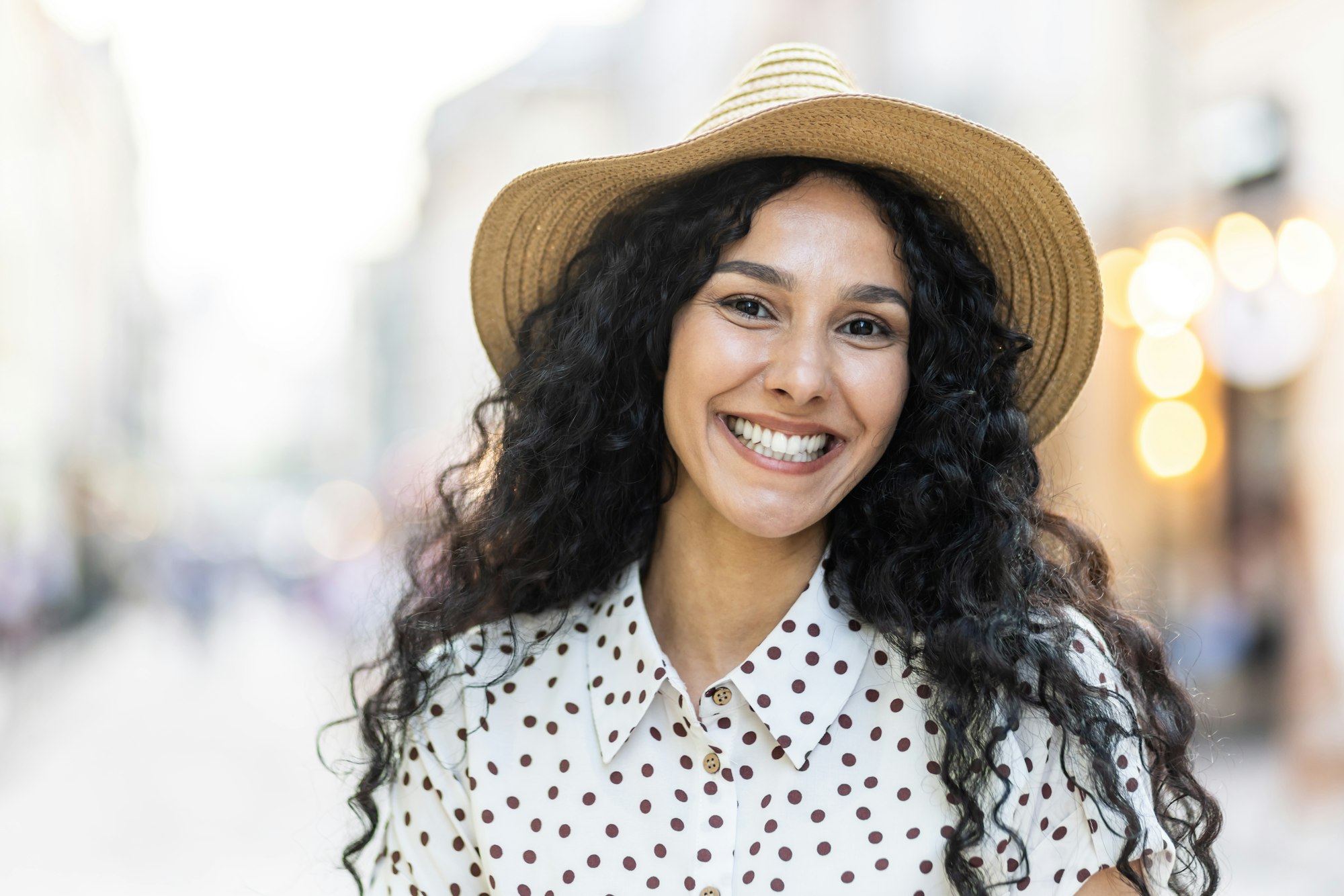 Confident latina businesswoman smiling in the city with bokeh lights