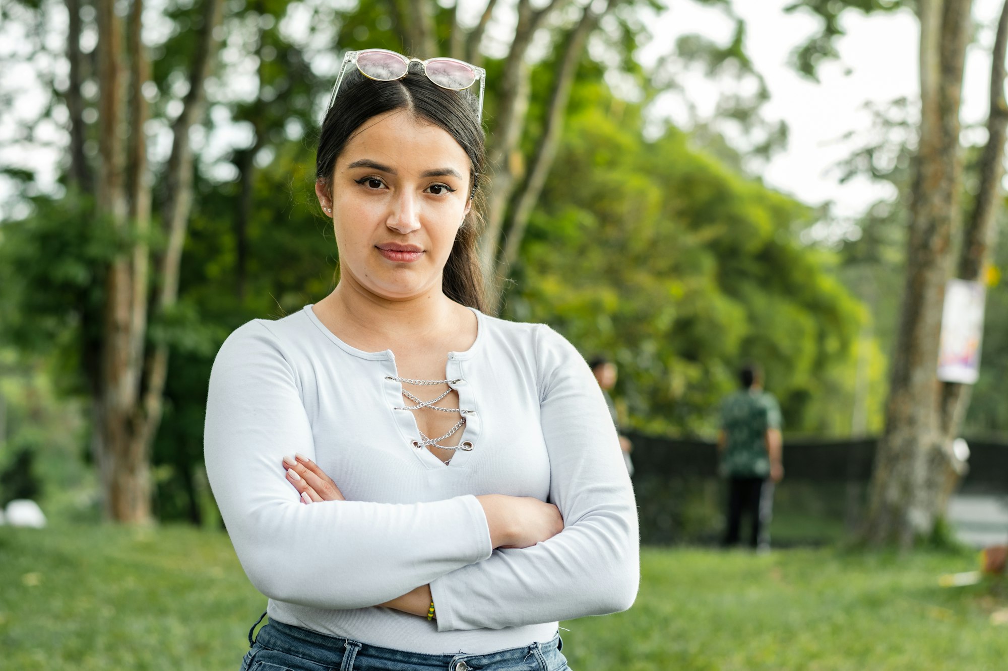 medium shot portrait of a latina woman looking serious in a park